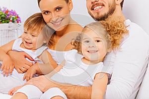 Happy parents with two adorable children on bed