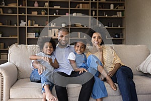 Happy parents and two kids enjoying leisure time at home