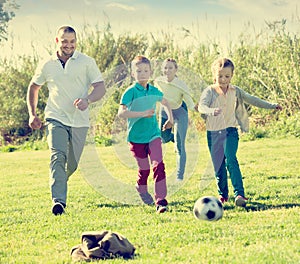 Happy parents with two kids playing soccer