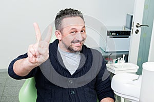 Happy patient sitting trustful on dentist chair