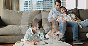 Happy peaceful parents relaxing on couch at home