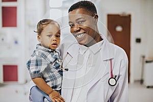 Happy pediatrician carrying a young boy photo