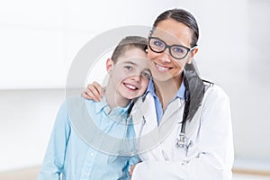 Happy pediatrician female doctor and young boy in ambulance. People and pediatry concept