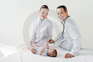 happy pediatricians listening breath of little baby