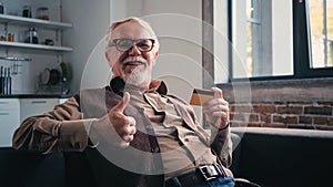 happy pensioner in eyeglasses holding credit