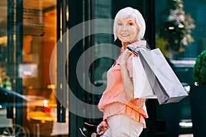 Happy pensioner in front of the shop doors