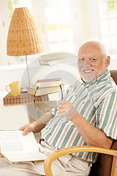 Happy pensioner reading at home photo