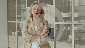 Happy pensioner, resting at home, smiling at the camera, posing against the background of the kitchen