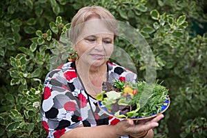Happy pensioner woman with vegetables at dacha