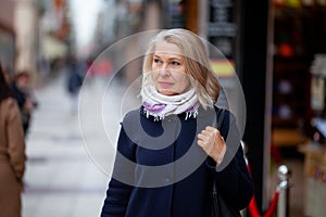 Happy pensioner woman walks the streets of a tourist city