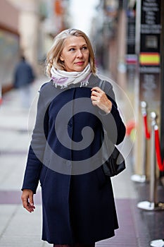 Happy pensioner woman walks the streets of a tourist city