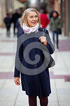 Happy pensioner woman walks the streets of a tourist city