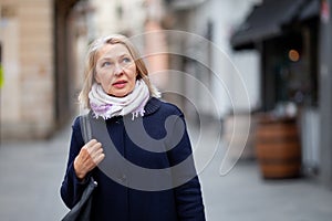 Happy pensioner woman walks the streets of a tourist city