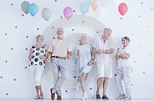 Happy pensioners holding balloons photo