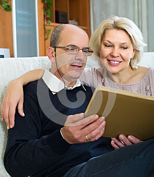 Happy pensioners watching old photoes