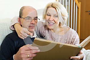 Happy pensioners watching old photoes