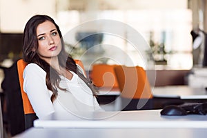 Happy pensive businesswoman planning and looking sideways at office