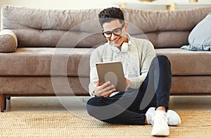 Happy pensive  man using digital tablet at home