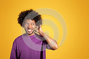 Happy pensive mature black curly man in violet t-shirt thinking and scratching head