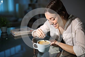 Happy pensive woman stirring coffee at home