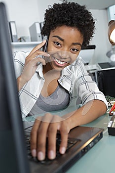 happy pensive young female calling business partner on mobile phone