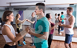 Happy people dancing bachata together in dance class