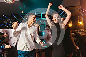 Happy people are dancing in club. Nightlife and disco concept