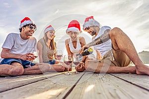 Happy people enjoying outdoor life in exotic vacation resort drinking alcohol. Group of young friends having fun together at