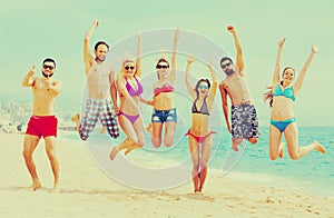 Happy people jumping on a beach