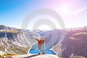 Happy people relax in cliff during trip Norway. Trolltunga hiking route. Toning picture