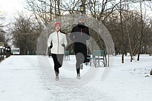 Happy people running in winter park. Outdoors sports exercises