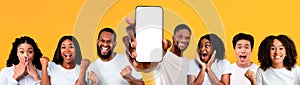 Happy people showing white empty smartphone screen and gesturing yes