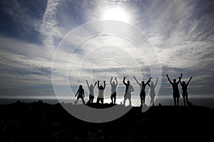 Happy people silhouettes on the beach