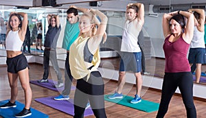 Happy people studying zumba elements in dancing class