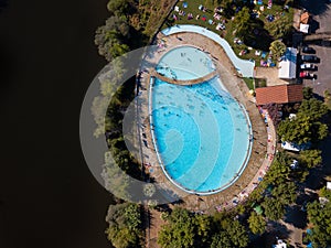 Happy people swimming on vacation. Aerial view over amazing pool. Drone point of view in summer landscape. Swimming pool in Mirand photo