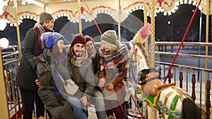 Happy people taking selfie photo on smartphone camera at New Year winter fair amusement park. Smiling friends have fun