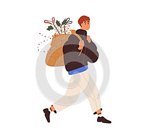 Happy person going with Christmas purchases in backpack outdoors. Man carrying gift boxes, presents, Xmas decoration for