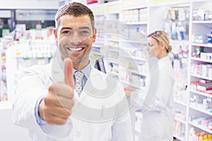 Happy pharmacist holding his thumb