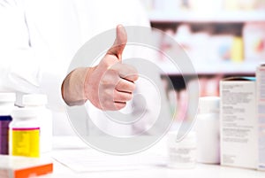 Happy pharmacist showing thumbs up at pharmacy counter