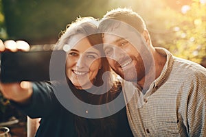 Happy, phone and couple love to take a selfie at an outdoor restaurant for a romantic date in spring. Relax, memory and