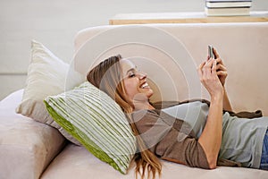 Happy, phone and woman on sofa to relax on social media, networking and browse internet. Smile, home and person on couch