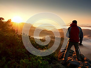 Happy photo enthusiast enjoy photography of fall daybreak in nature on cliff