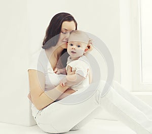 Happy photo young mother with baby at home in white room