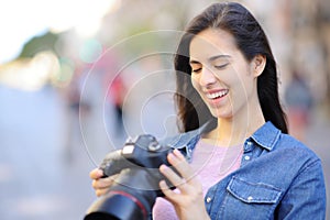 Happy photographer checking pictures on camera