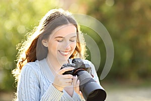 Happy photographer checking pictures on camera