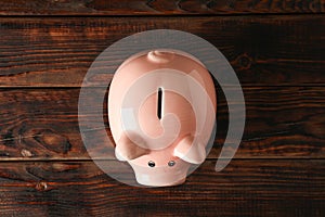 Happy piggy bank on wooden background, space for text and top view