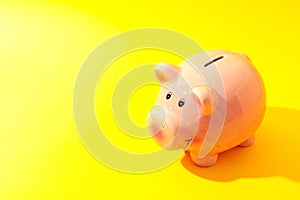 Happy piggy bank on yellow background, space for text