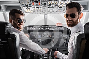 happy pilots in sunglasses and uniform