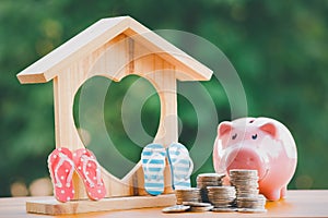 Happy Pink Piggy Bank and Home wooden in close-up and coins stack in the nature background, Saving ideas  and investment budget, B