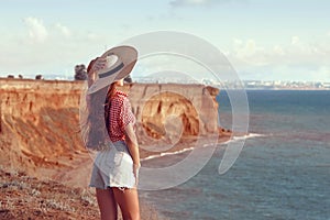 Happy pinup girl outdoor portrait. Travel vacation fun summer woman with hat enjoying freedom over Black sea. Carefree girl